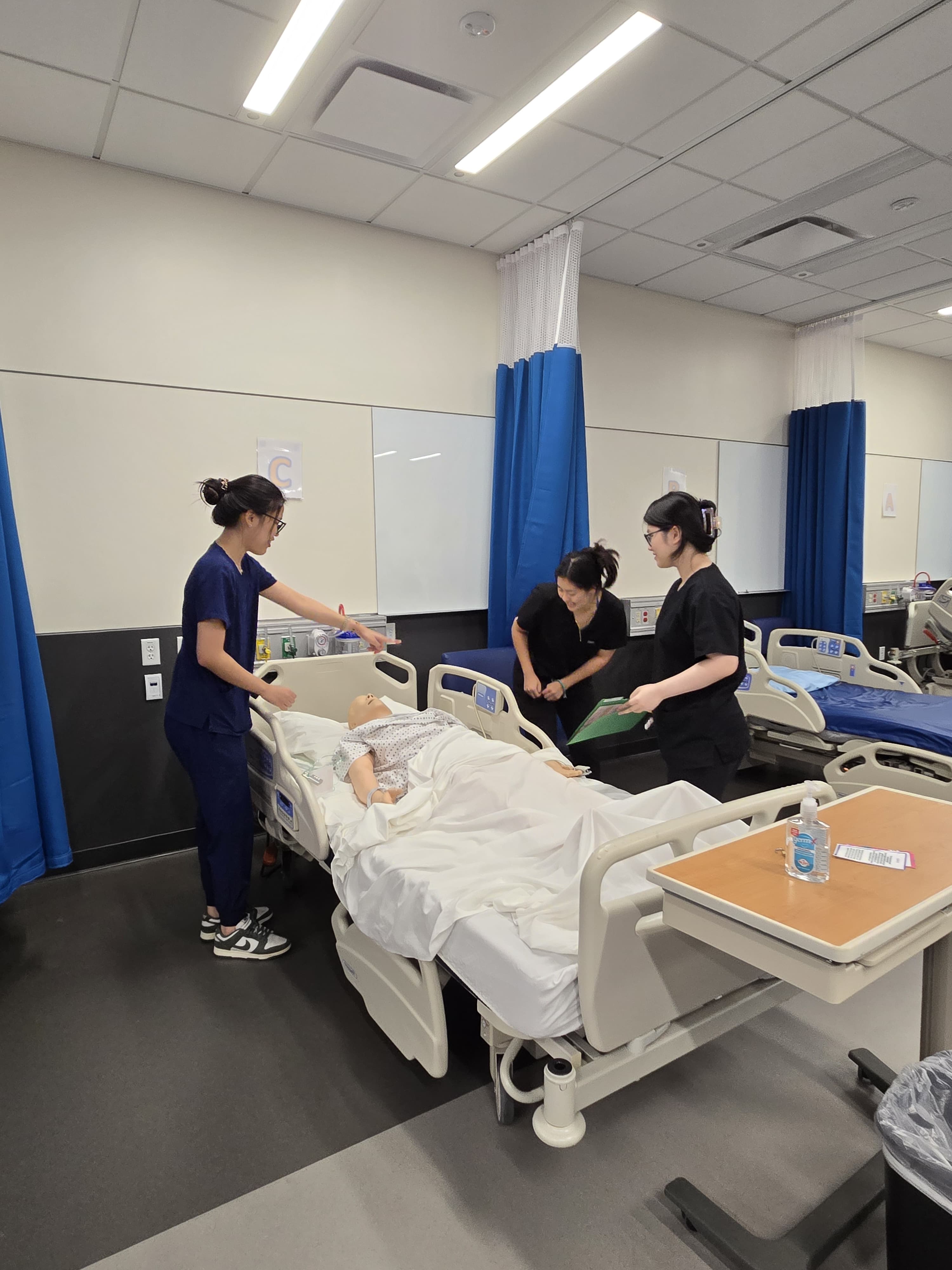 Three individuals attending to a patient in a hospital setting.