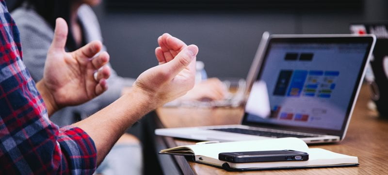 student guestures about something on laptop