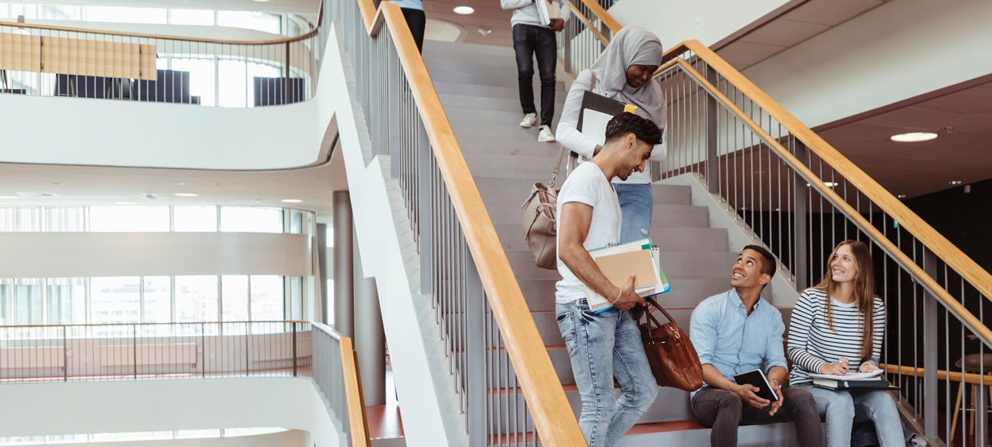 Students hanging out on the stairs in west hall