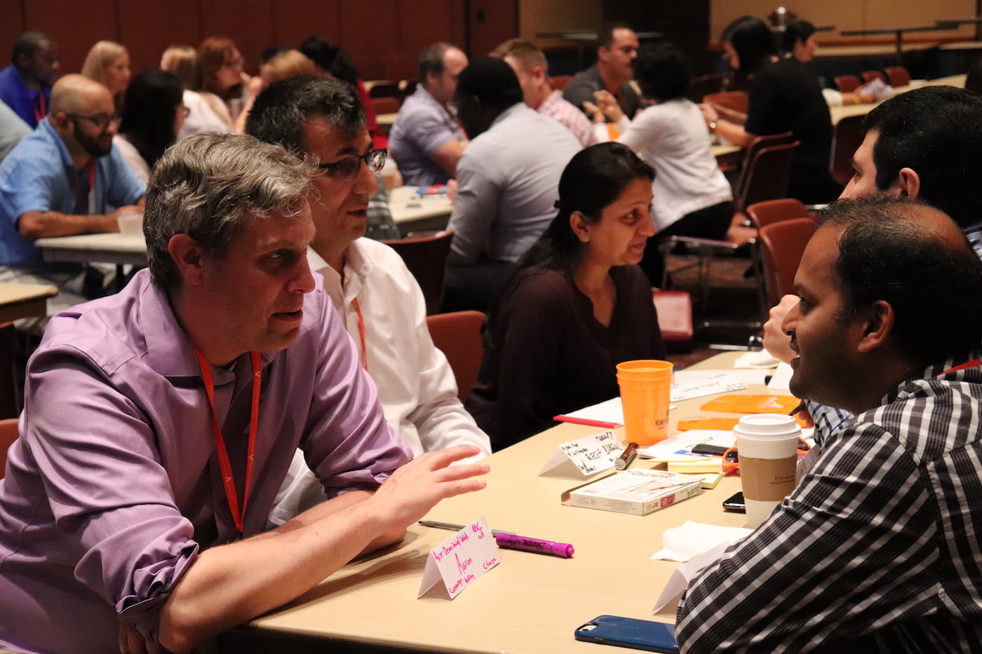 UTA Faculty members sitting and talking amongst themselves at an event 