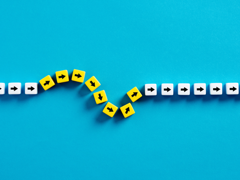 A curved path of yellow and white square tiles forming a wave-like pattern on a bright blue background.