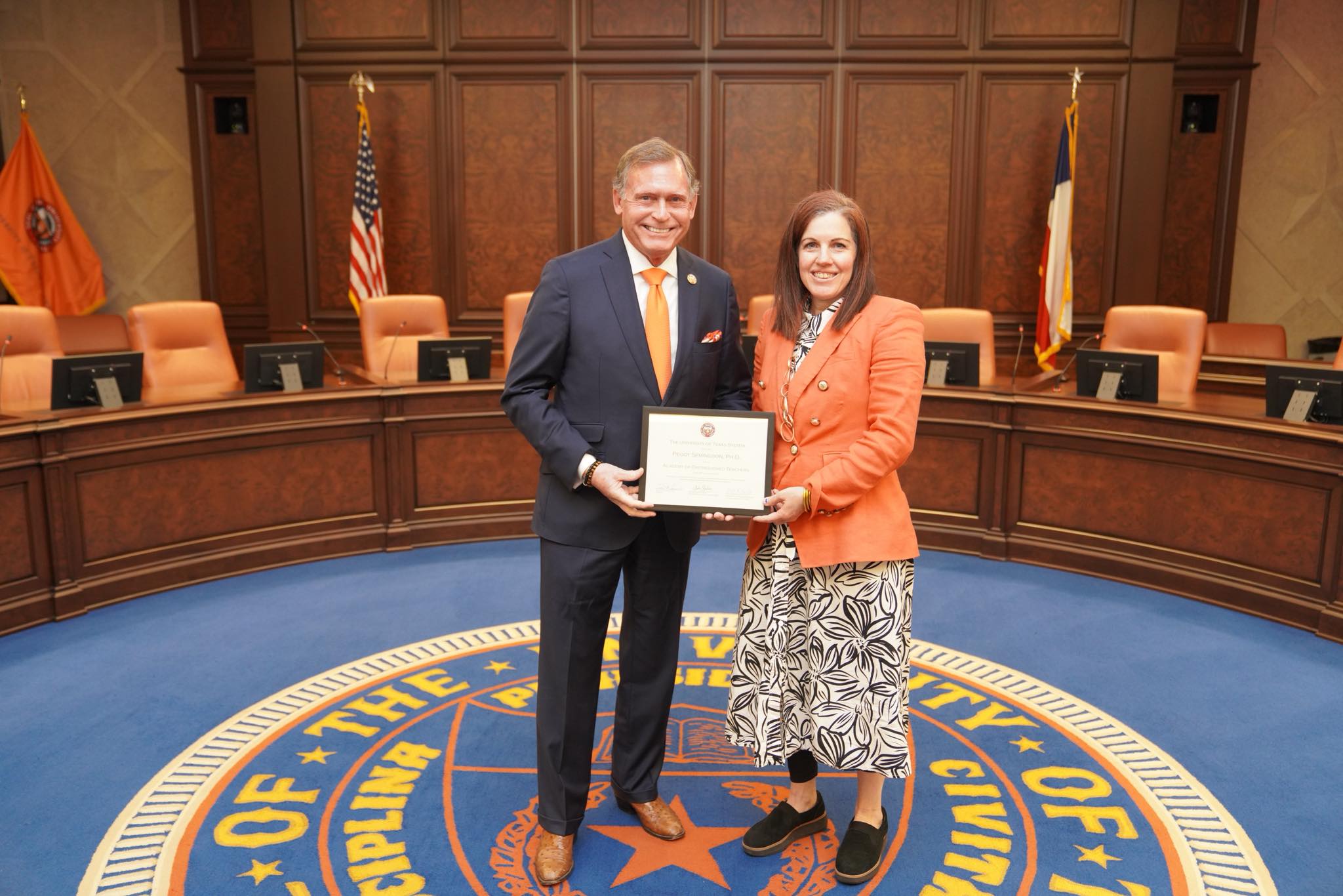 Dr. Peggy Semingson holding her induction certificate at the UT System Academy of Distinguished Teachers ceremony