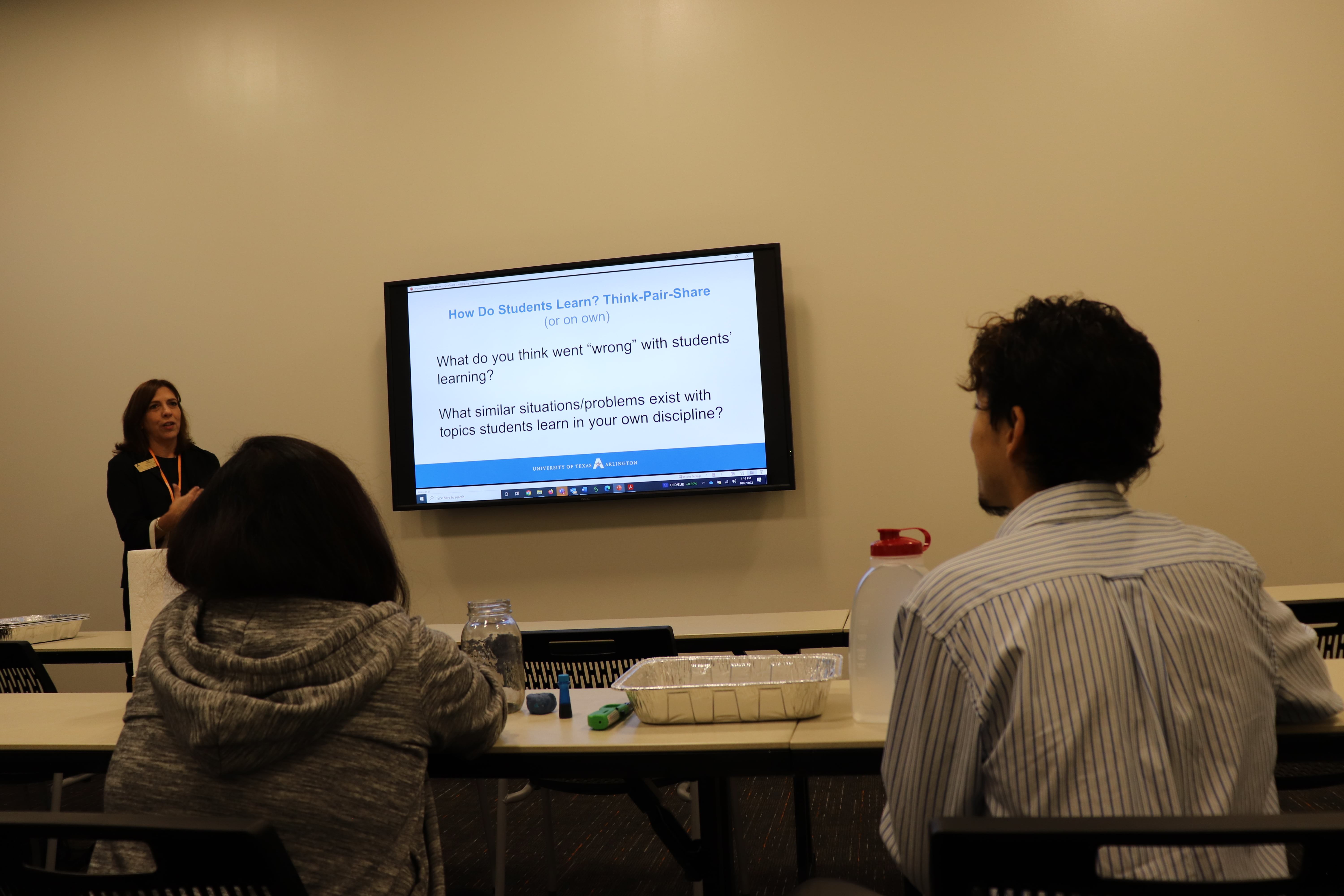 person presenting in the front and others listening in the audience