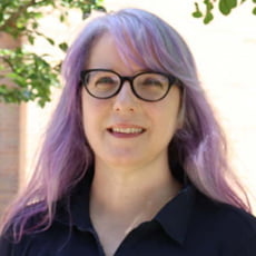 picture of Alicia Soueid, dressed in a dark shirt with dark rimmed glasses.