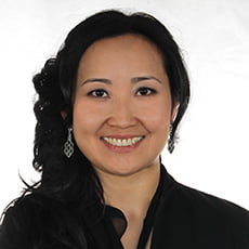 picture of Saltanat Childress, dressed in a dark formal shirt with dangling earrings