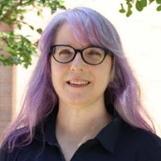 picture of Alicia Soueid, dressed in a dark shirt with dark rimmed glasses.