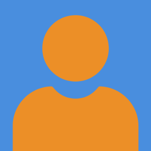 picture of Kathleen Tice, dressed in a blazer with a necklace on, posed in a children's classroom