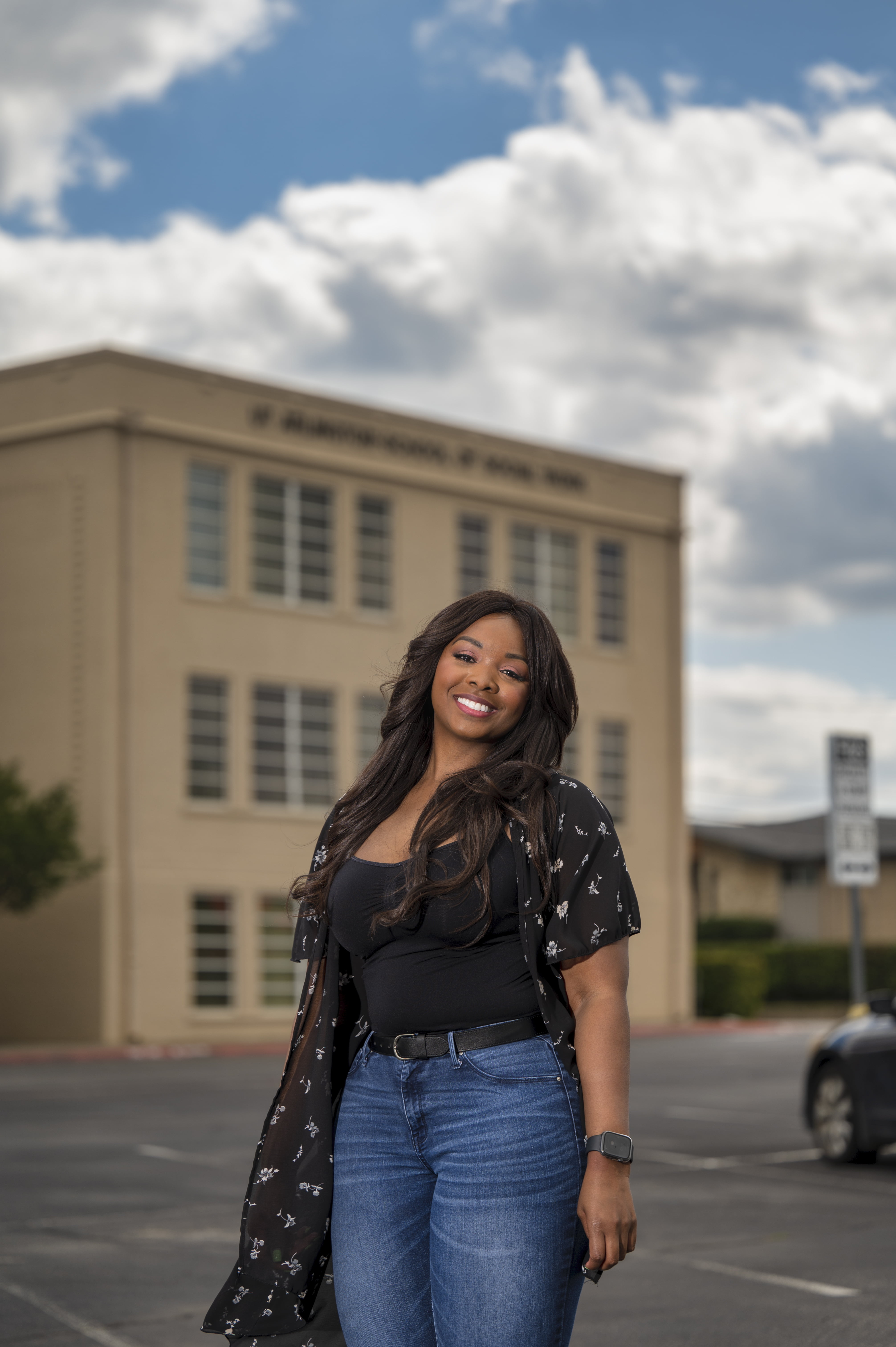 Jami Walton standing in front of the Social Work building at U T A 