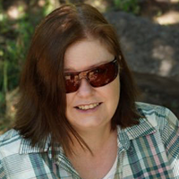 headshot of Dr. Kimberly H Breuer wearing glasses and a pattered shirt