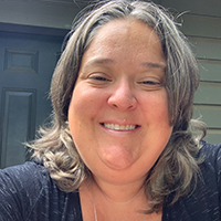 headshot of Dr. Sarah Alice Shelton wearing a dark shirt and a necklace