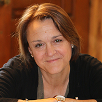 headshot of Dr. Stephanie Cole wearing a dark cardigan over a blouse, arms folded with a watch on her wrist