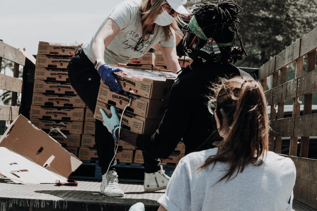 volunteers handing a pallet of fruit to each other
