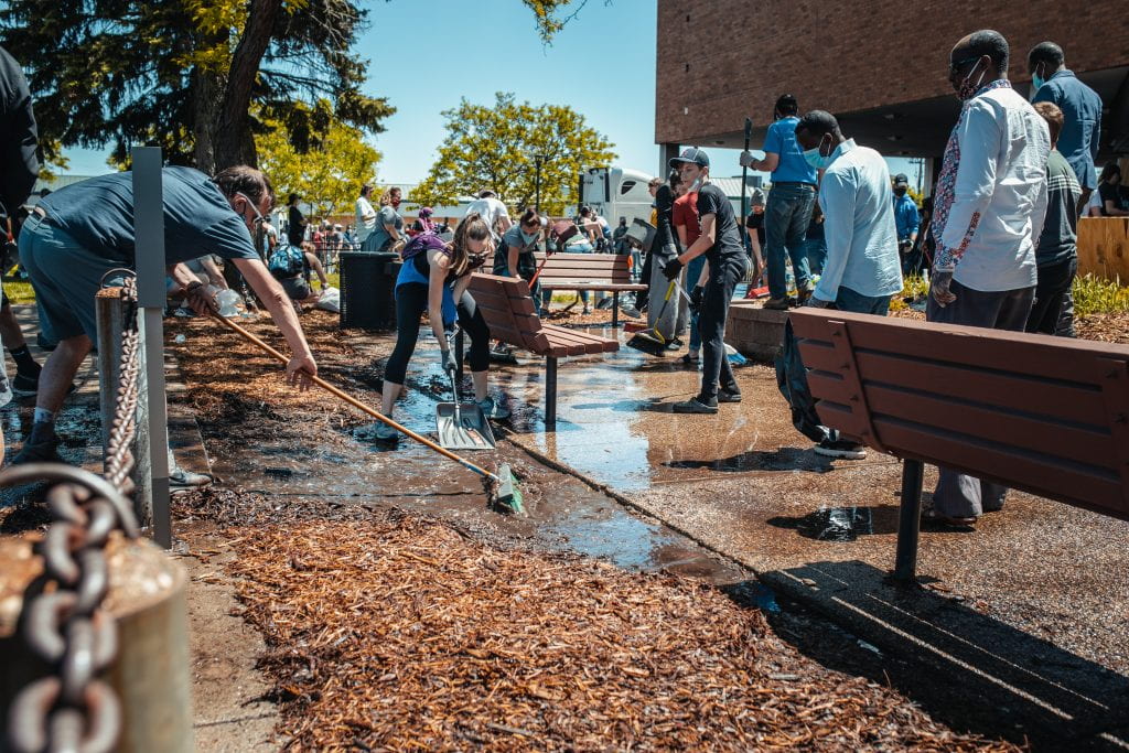 volunteers helping clean up a seating area outside