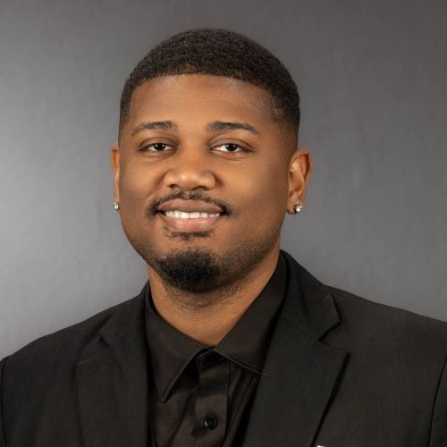 smiling man in a black suit and tie