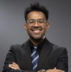 man in dark tie and jacket smiling