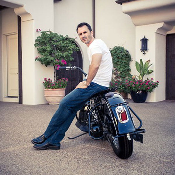 Adam Smith sitting on the side of a motorcycle 