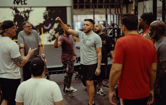 UTA alumnus Anthony Angula training a group of people at his physical training workplace gym