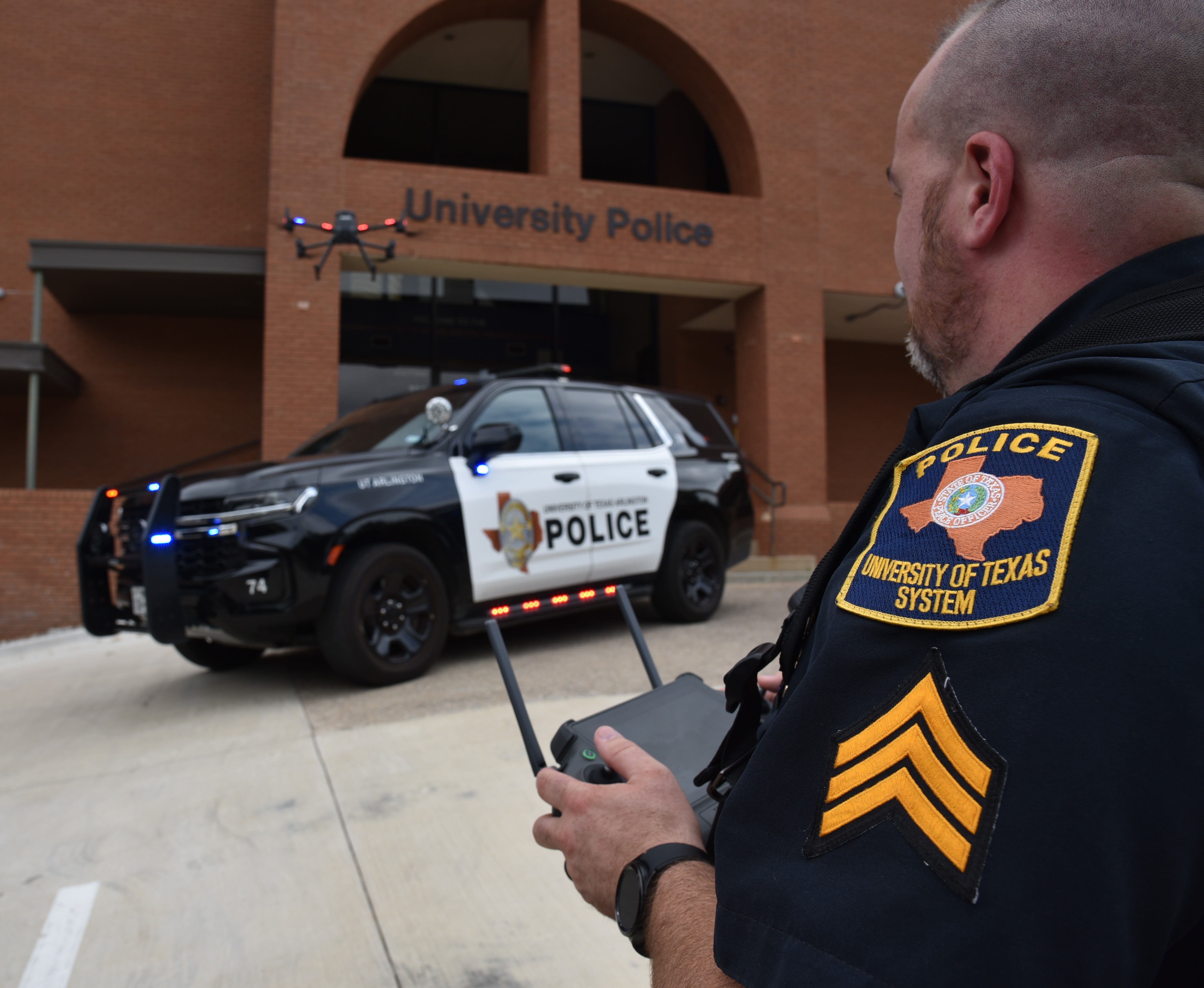 police vehicle and officer operating drone