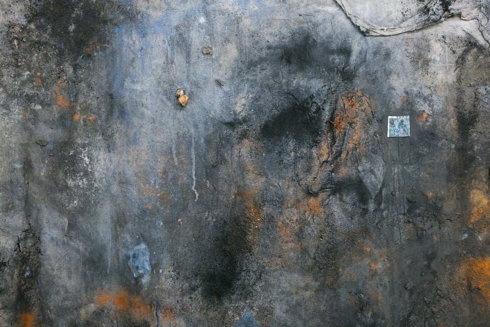 Artwork with different shades of bark color and few spots of orange and a small square tile.