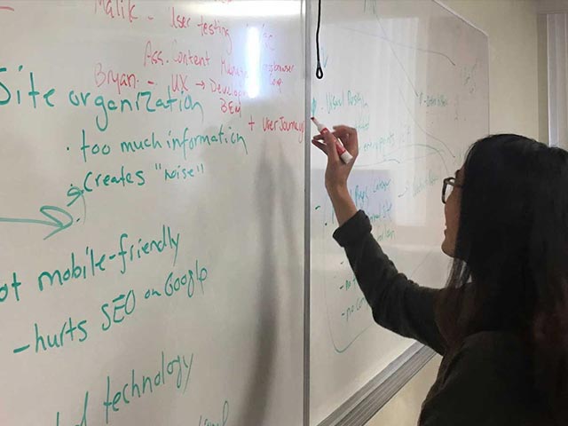 Person writing on a white board