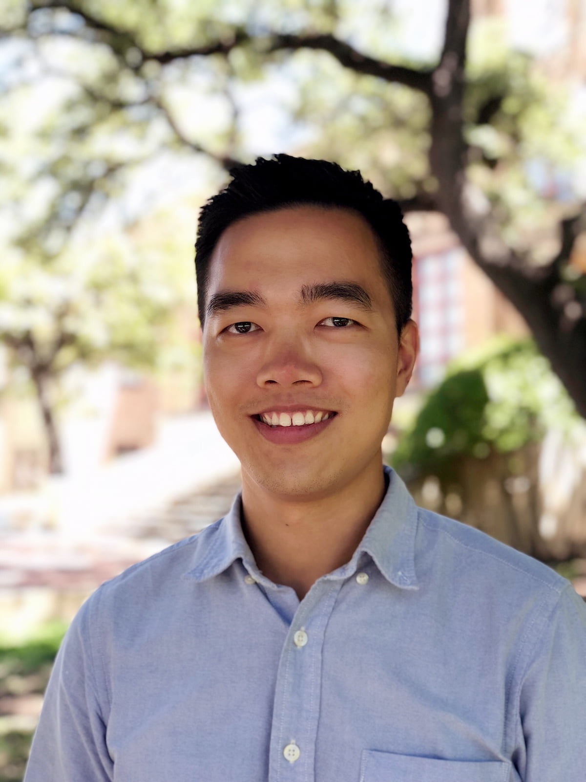 Weiwen Zeng smiling with short hair and wearing a button up