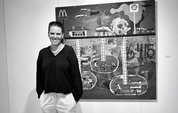 Emelie Stenhammar standing in front of one of her artworks.