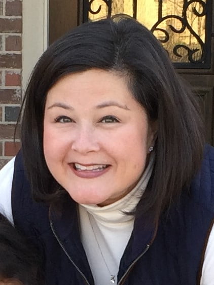 Jenny McMillen Sweeney smiling with a long-sleeve shirt and a zipper vest on