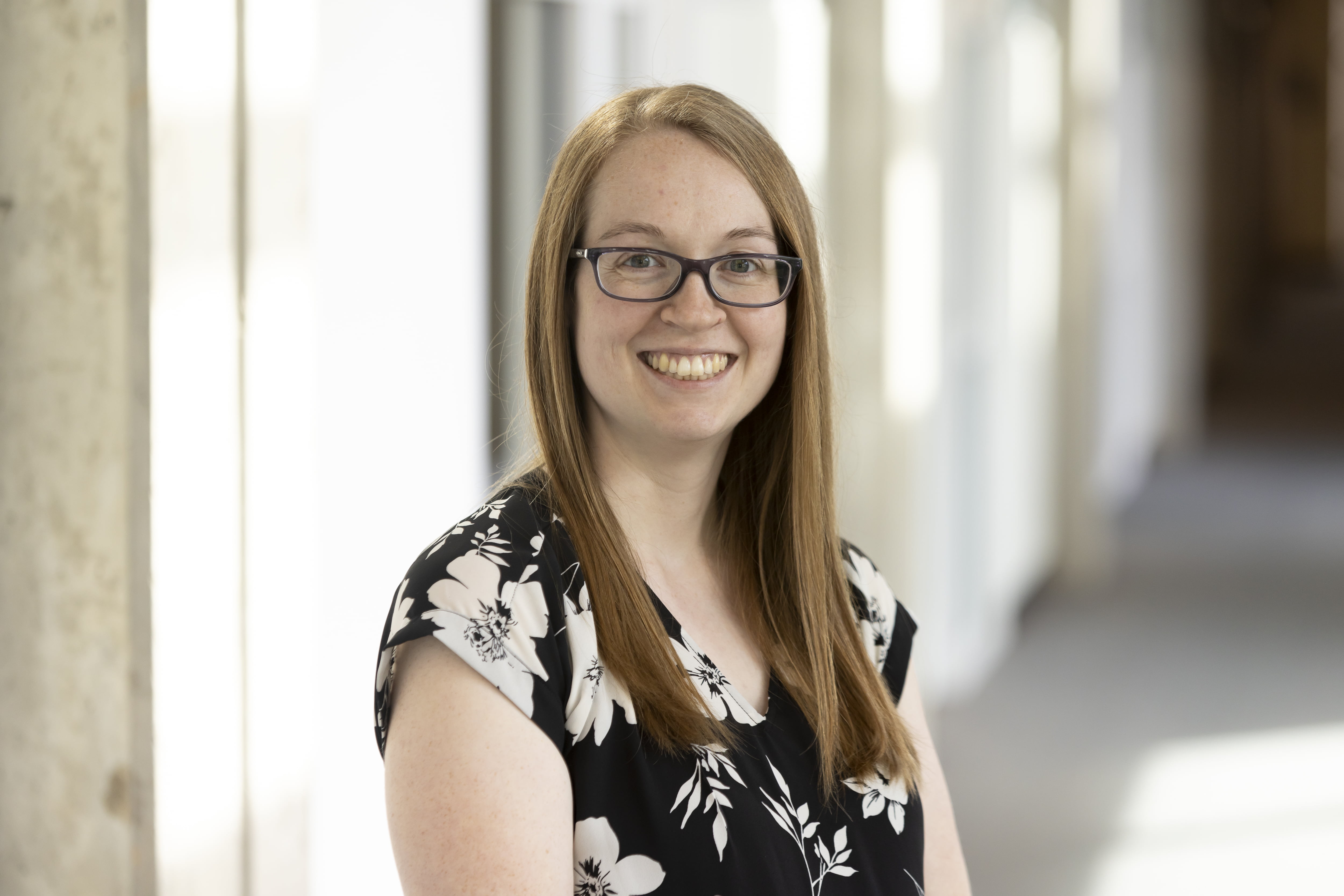 Jessica Marsh smiling while dressed in a formal blouse and wearing glasses