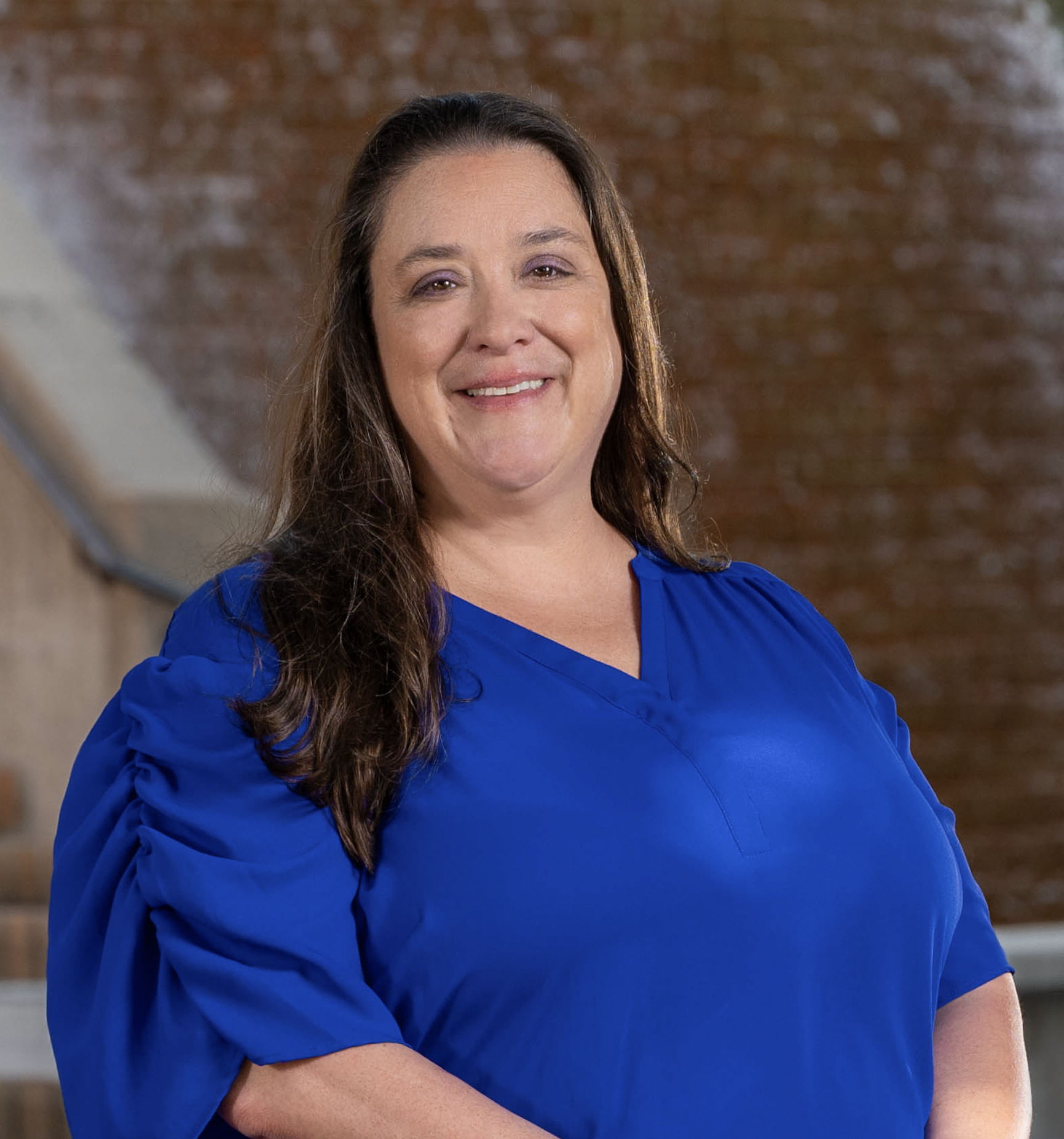 Dean Elizabeth Newman smiling in front of the central bridge's water foundation.