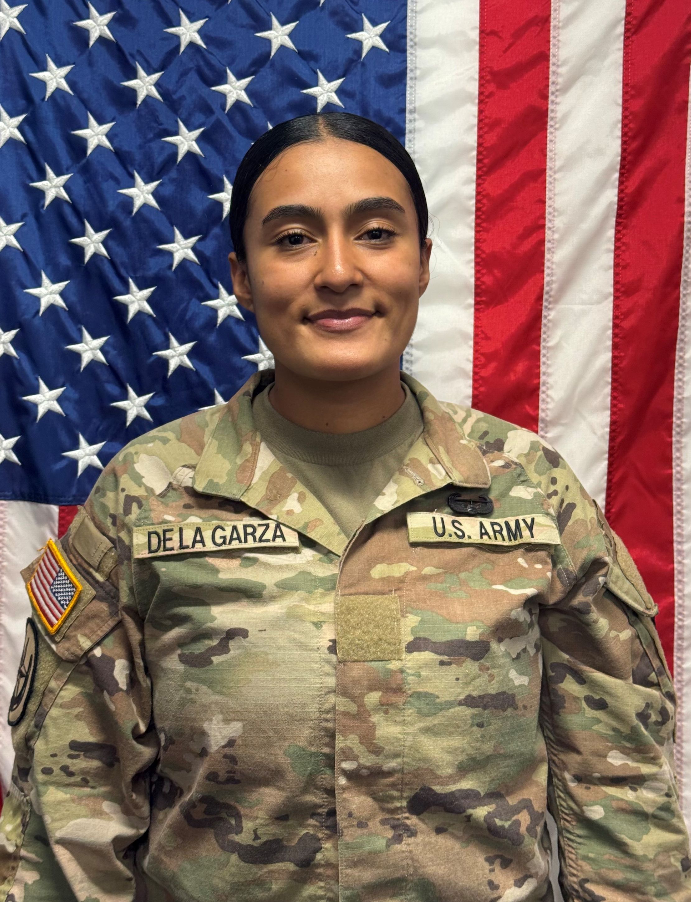 Cadet De La Garza standing in front of a U S A flag in uniform.