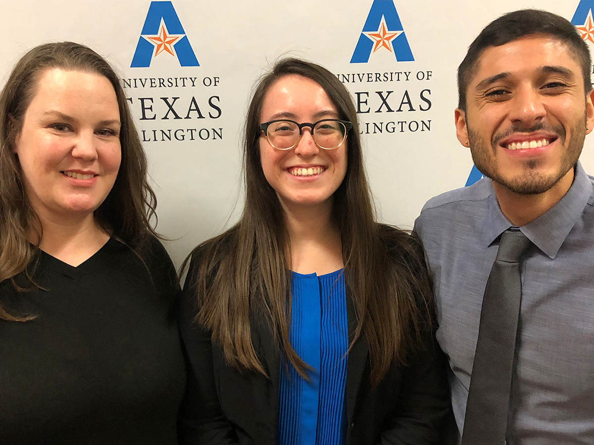 students smiling in front of backdrop