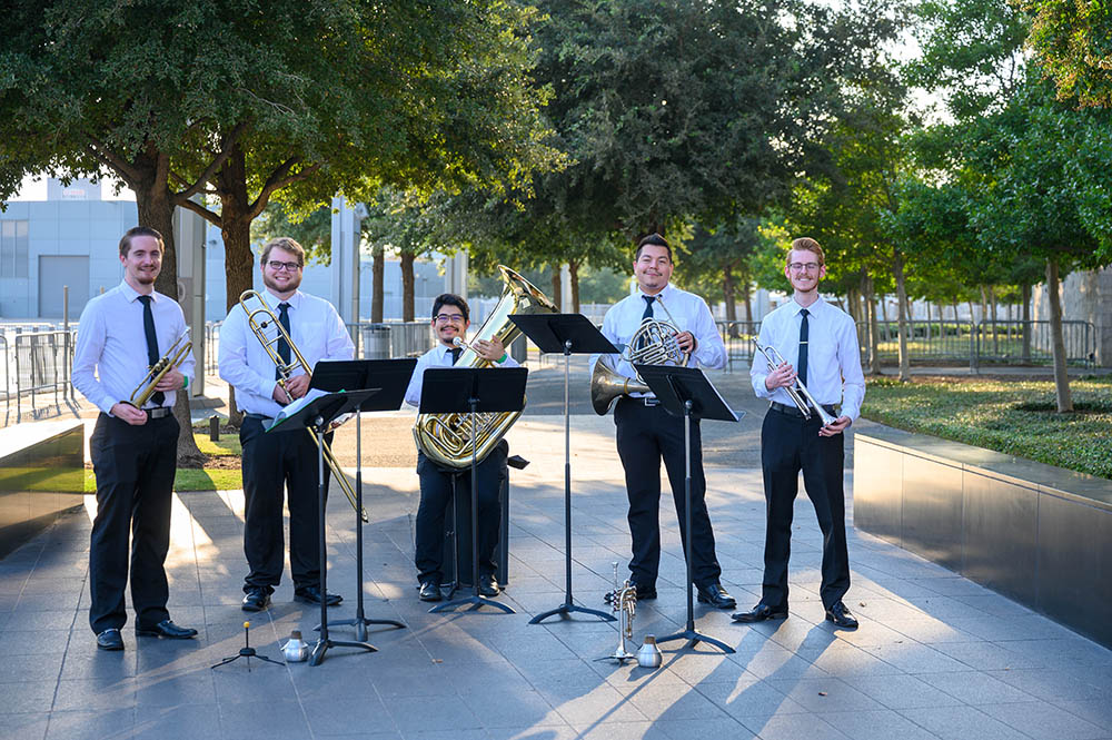 five band members posint with thier instruments
