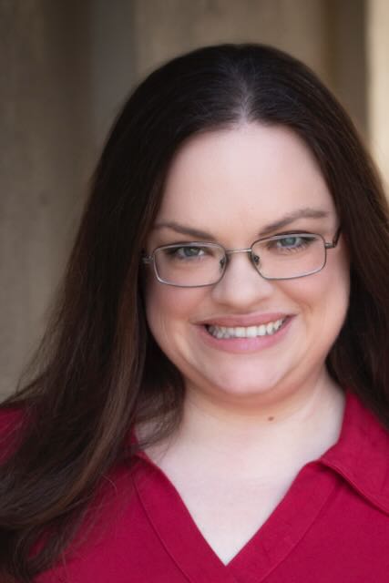 Dr. Alida Liberman smiling with glasses and long hair.