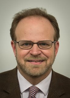 Martin Gallagher headshot wearing a suit and glasses