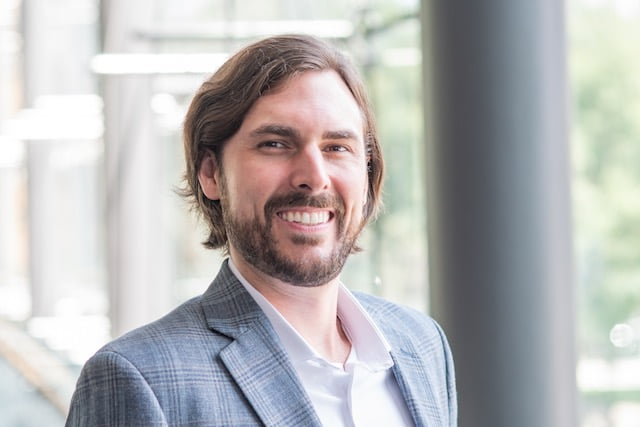 Peter Zuk wearing a suit and smiling