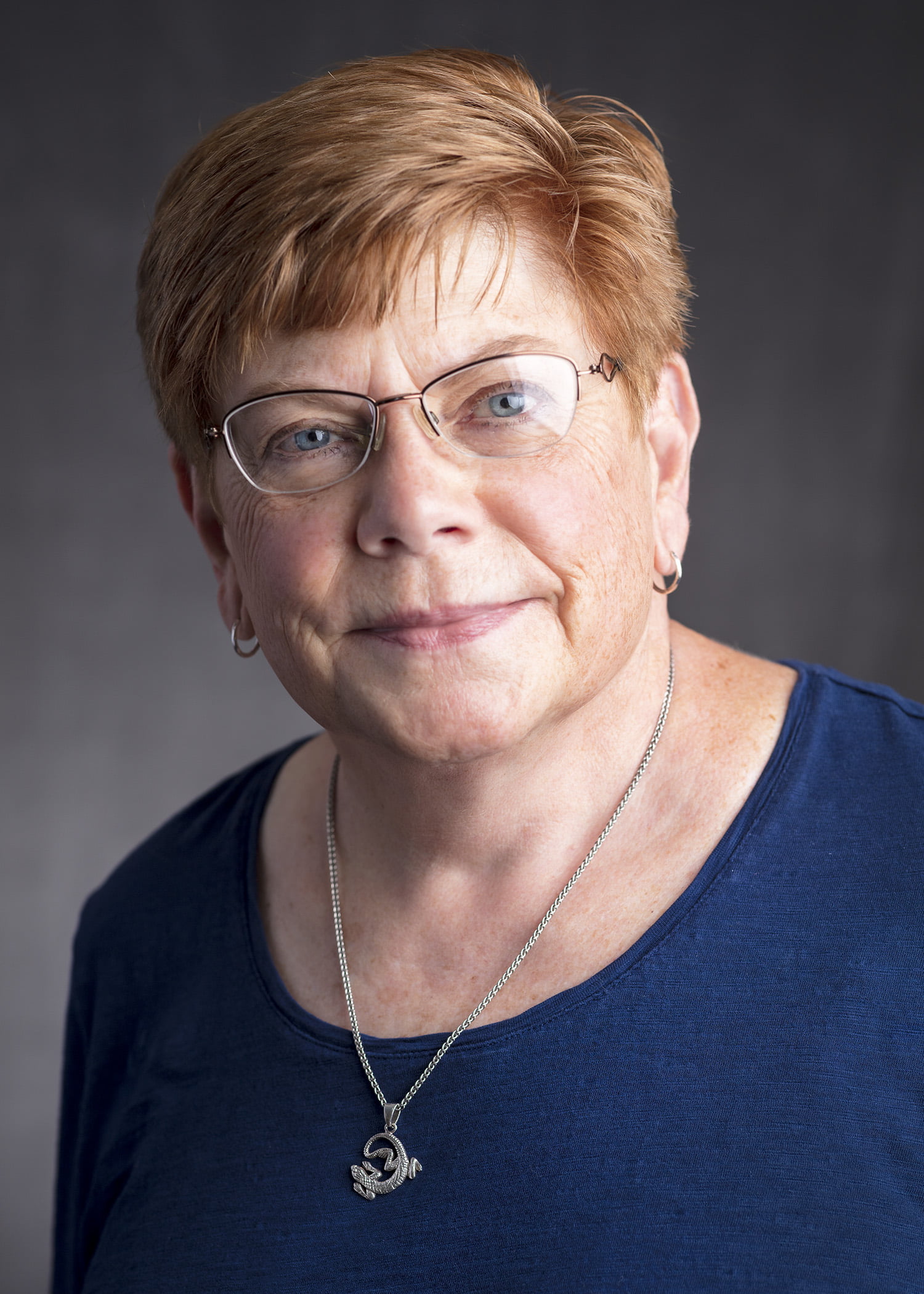 Katrina Nuncio posed with glasses, a necklace, and a dark blouse.