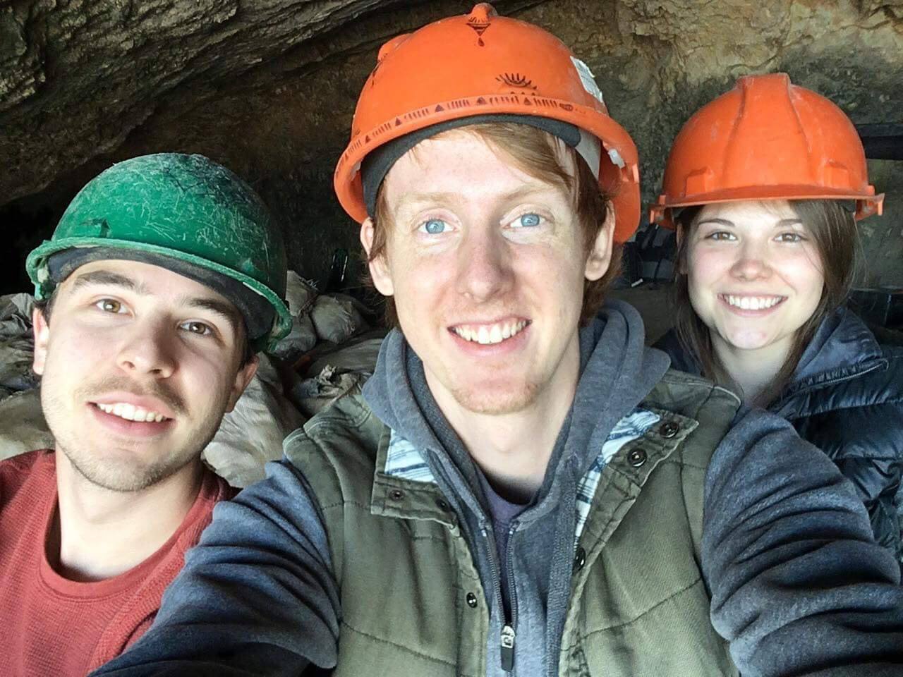 A photo of three people wearing orange hats .