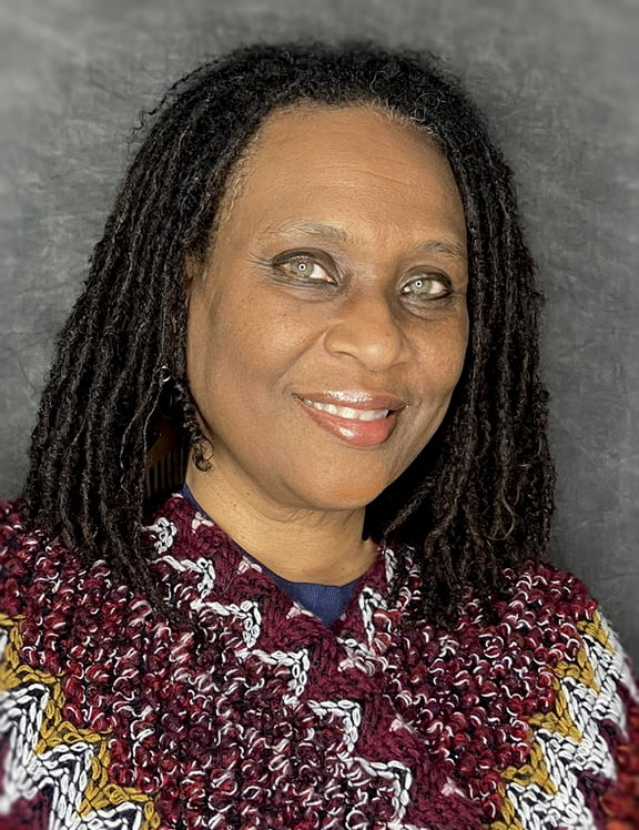 Photo of Kelley Smith smiling and wearing a vibrant shawl