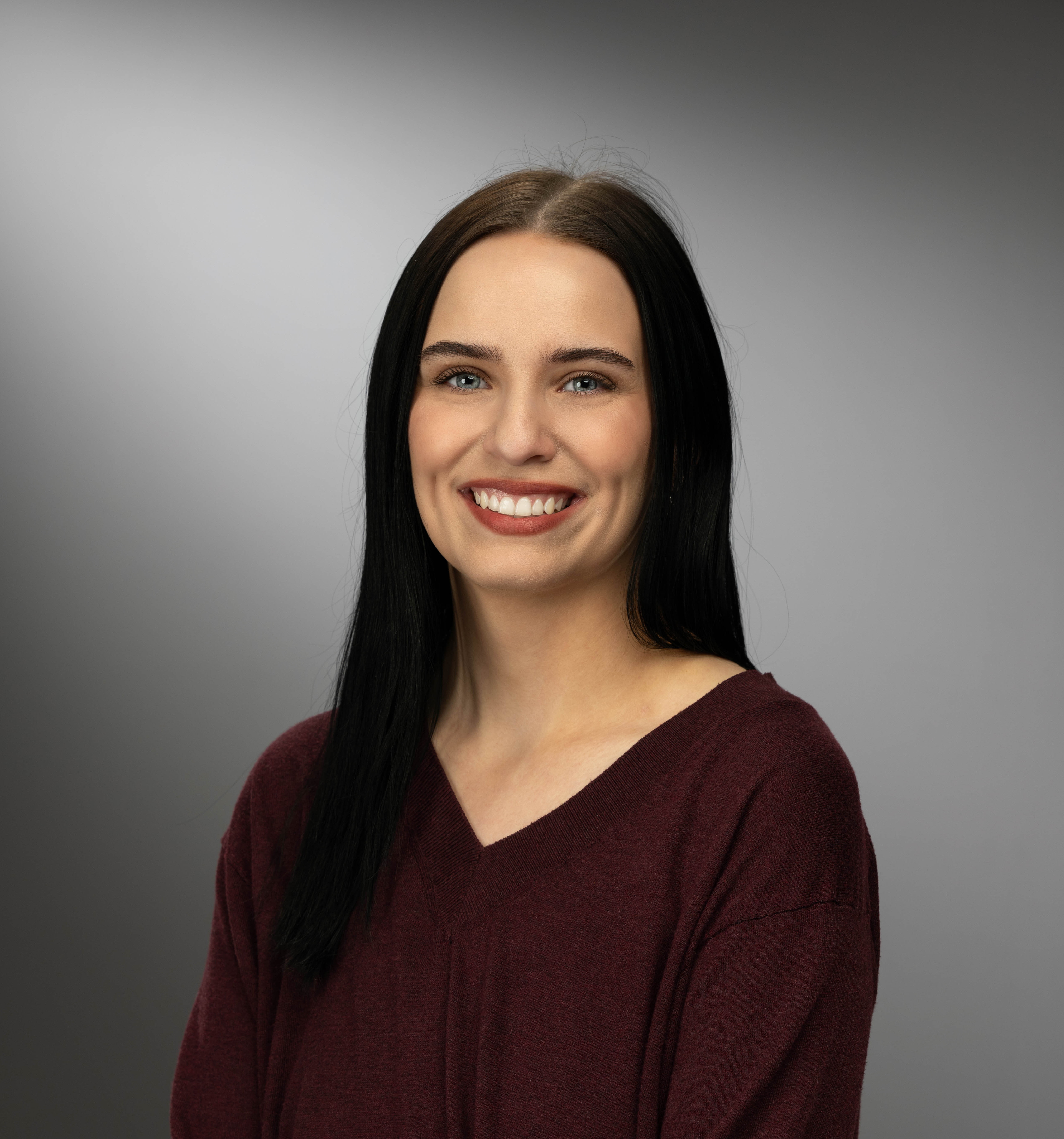 Taylor Hoyt smiling headshot with grey background