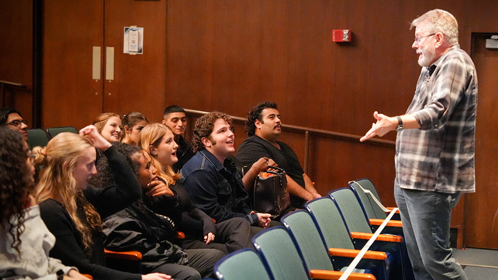 Person talking to a group of students.