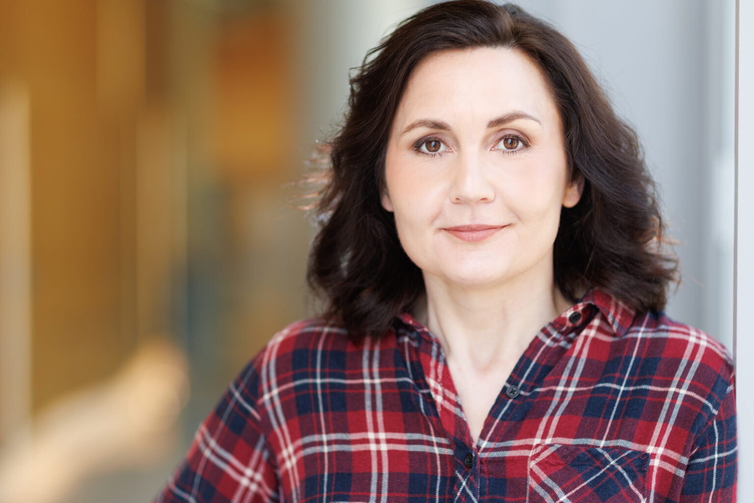 Alice Nelson with shoulder-length dark brown hair and wearing red and blue plaid shirt