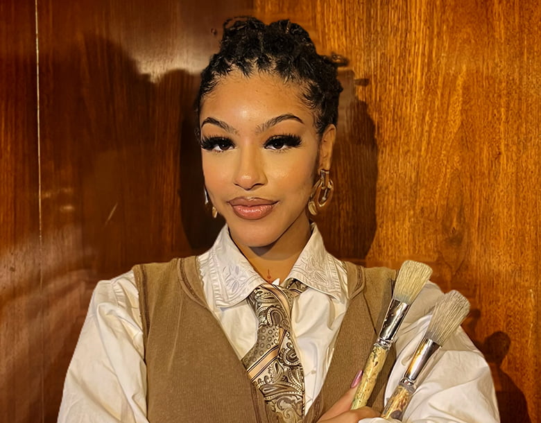 Gabby holding paint brushes.