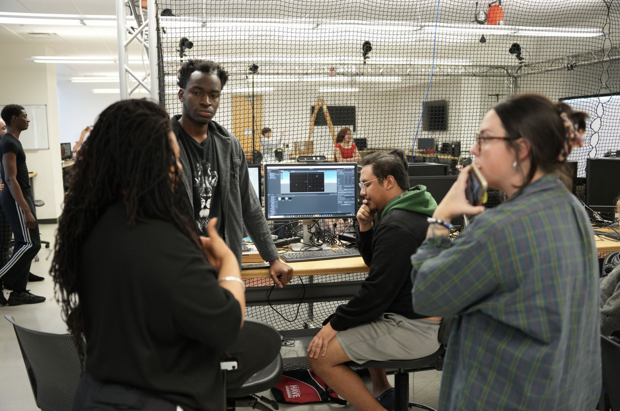 Four people brainstorming around a computer
