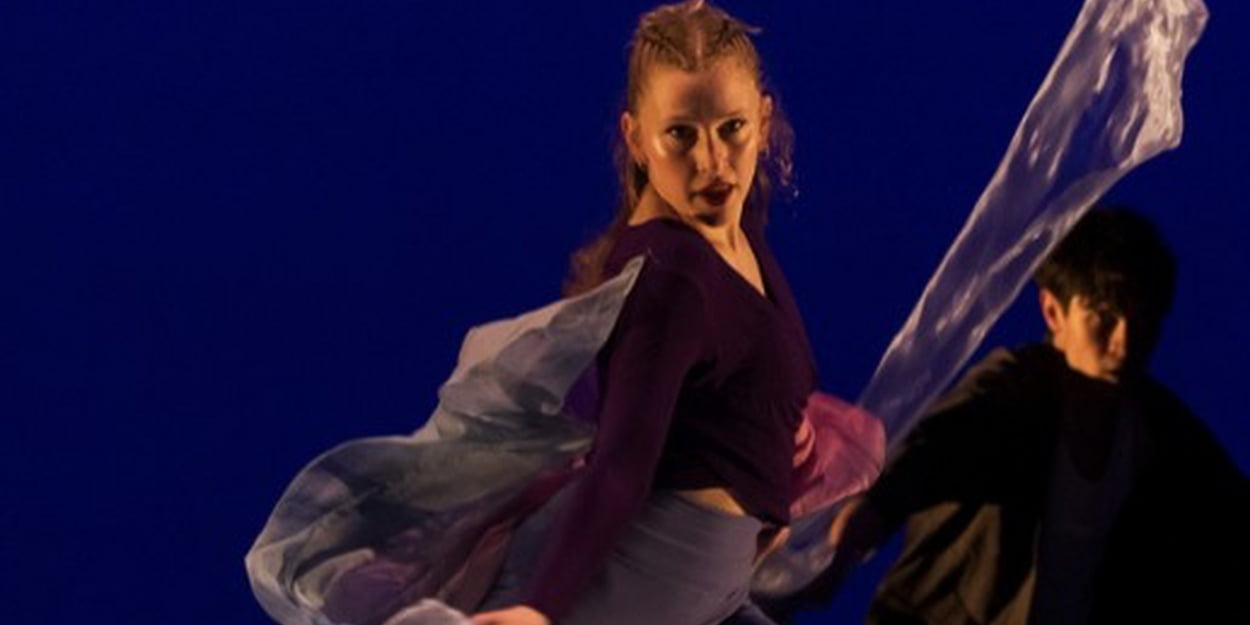 Closeup of dancer in motion with dark blue background.