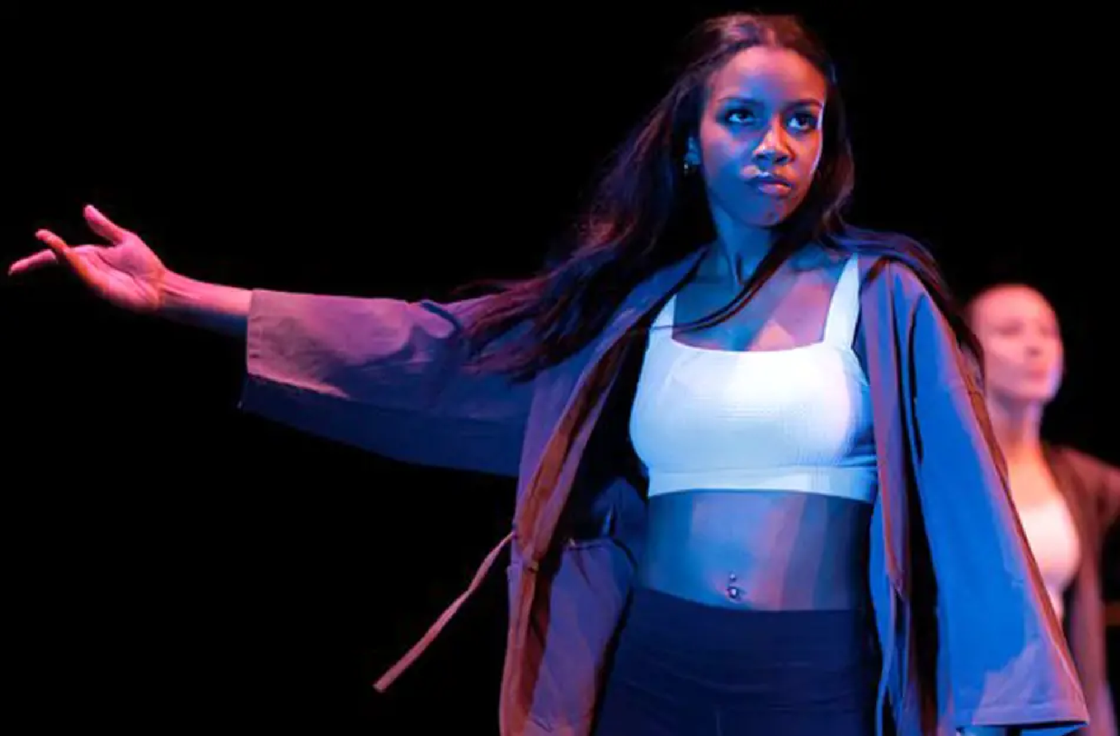 Closeup of dancer with arm outstretched to the side.