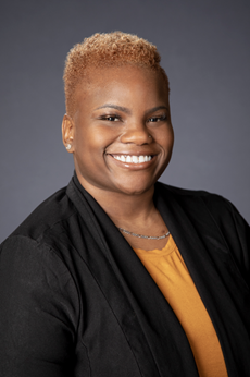 Smiling African American woman in gold blouse, dark blazer