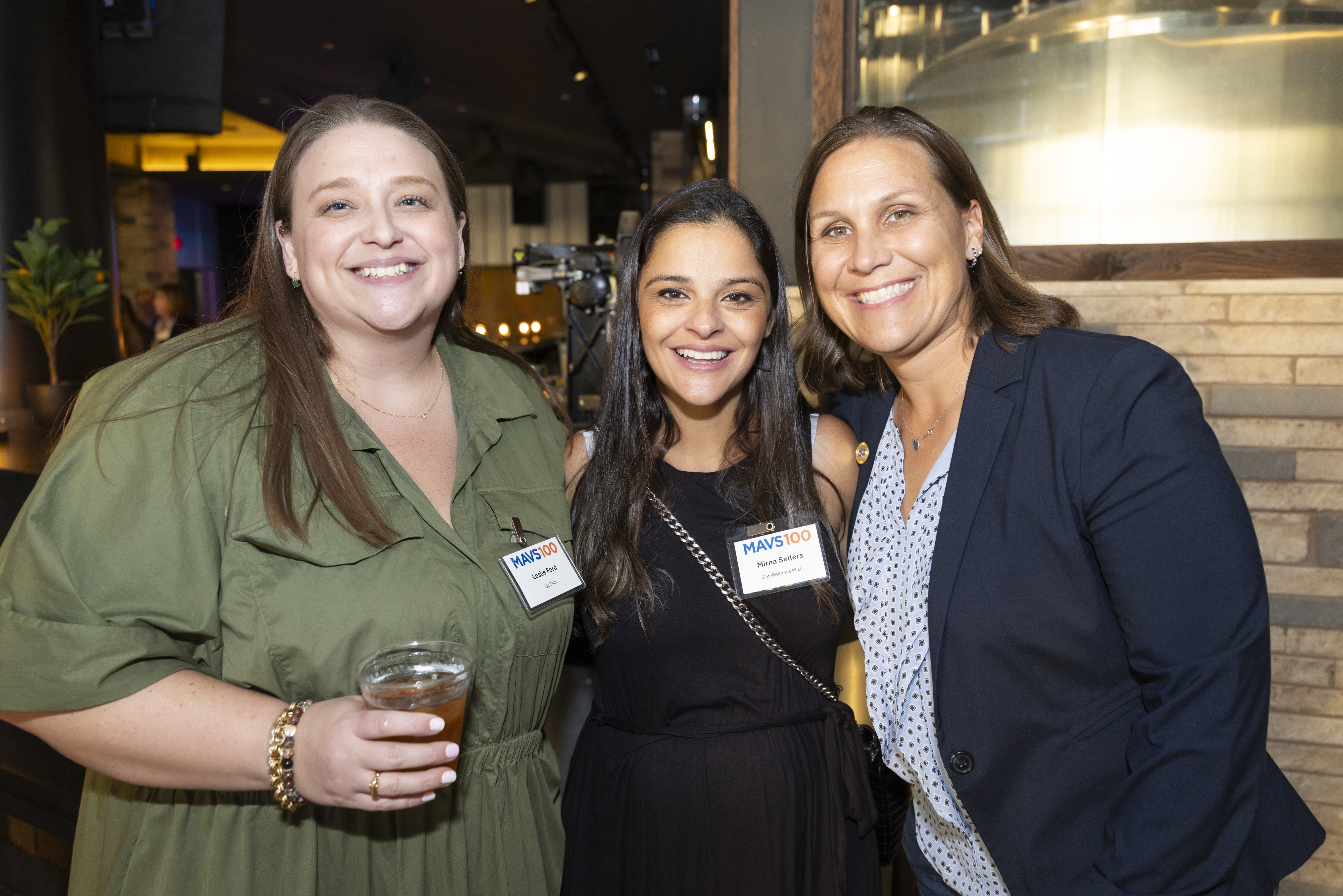 Three attendees pose for a photo together.