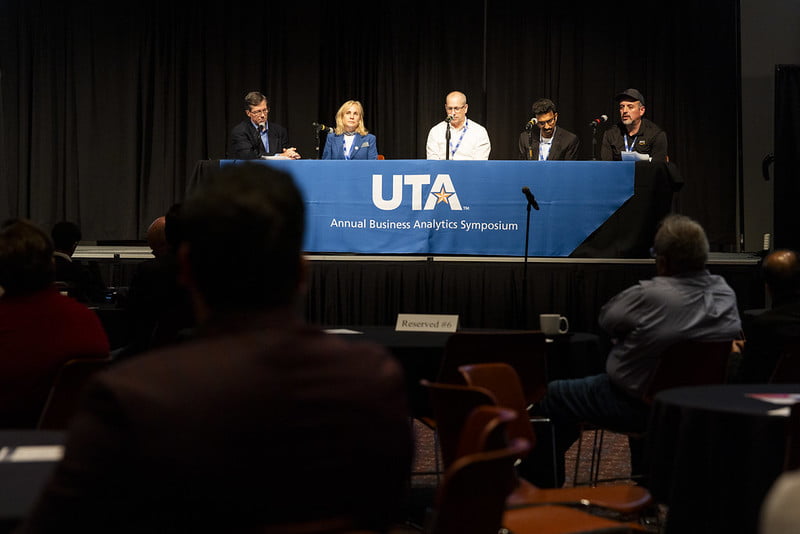 Four panelists and one moderator sit on stage.