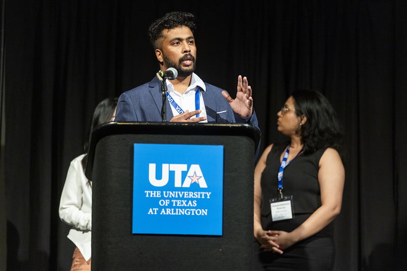 Graduate student Samuel Mamootil speaks to attendees from a podium.