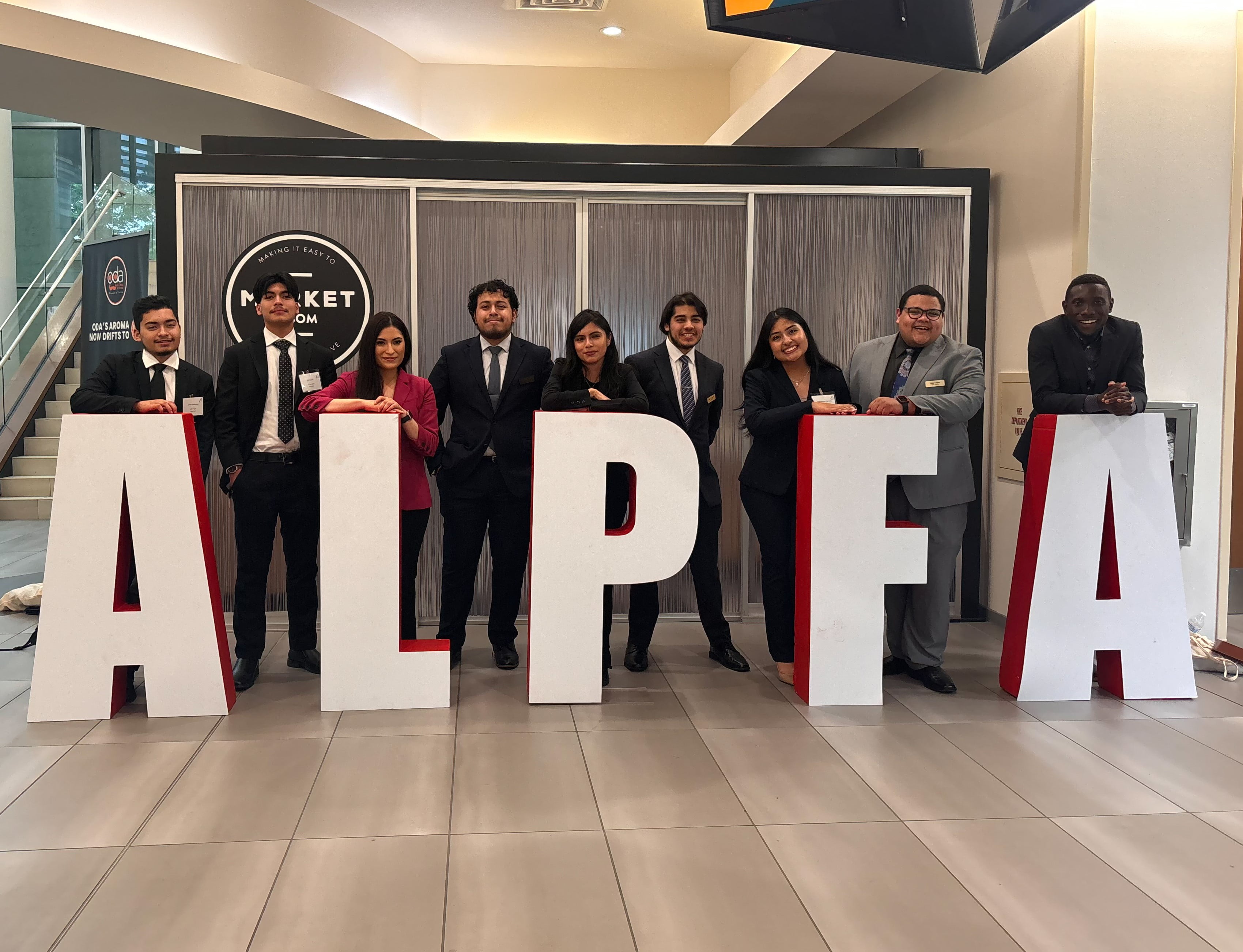 Members of the UTA ALPFA Chapter pose next to a large sign representing the organization. (Courtesy Photo) 